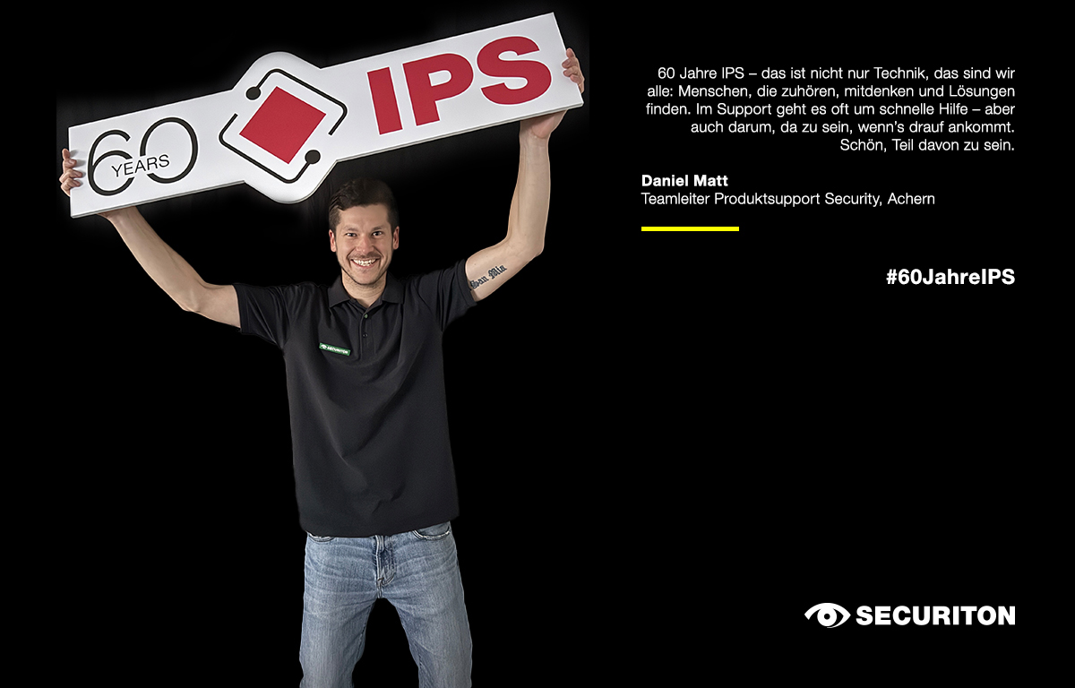 Ein Kollege streckt das 60 Jahre IPS-Logo in die Höhe. Rechts daneben stehen seine Glückwünsche zum Jubiläum.