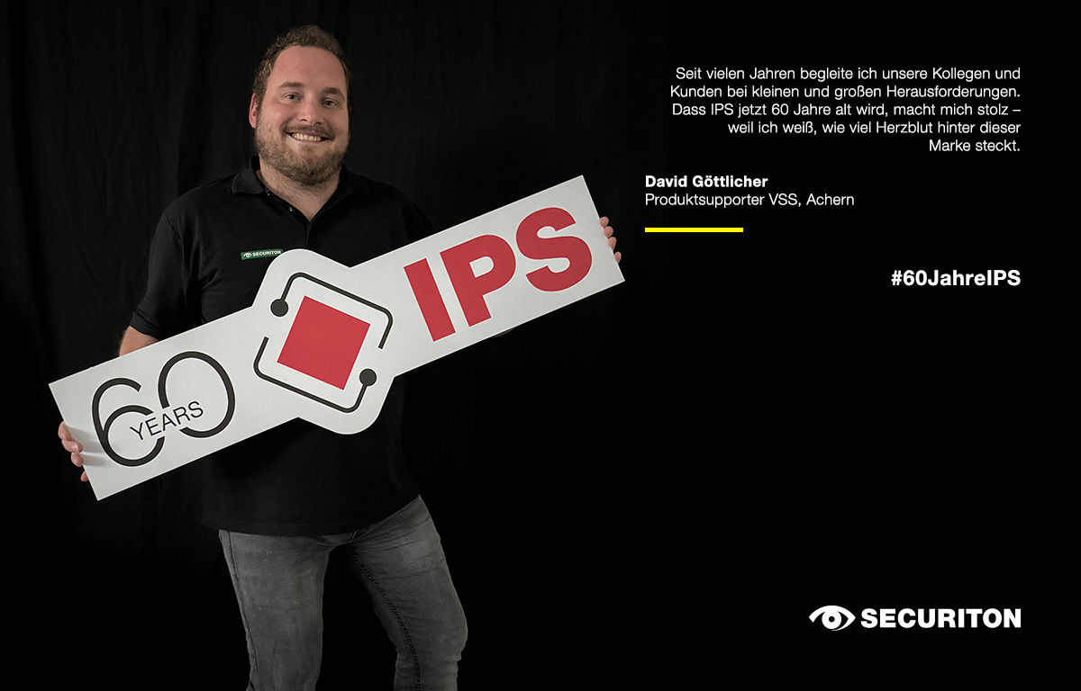 Eine Person hält das 60 Jahre IPS Logo in den Händen. Rechts daneben steht ein Glückwunsch zum Geburtstag.