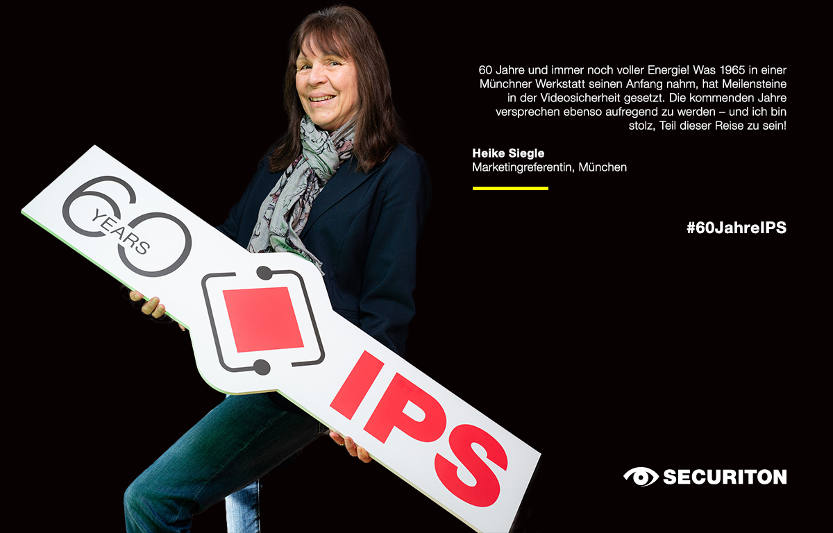 Eine Kollegin hält das 60 Jahre IPS Logo in den Händen. Rechts daneben steht ein Glückwunsch zum Geburtstag.