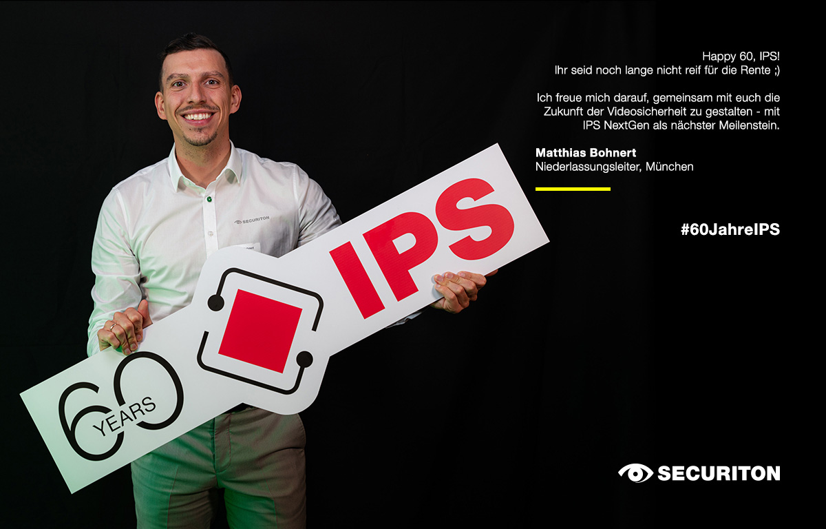 Ein Kollege hält das 60 Jahre IPS Logo in den Händen. Rechts daneben steht ein Glückwunsch zum Geburtstag.