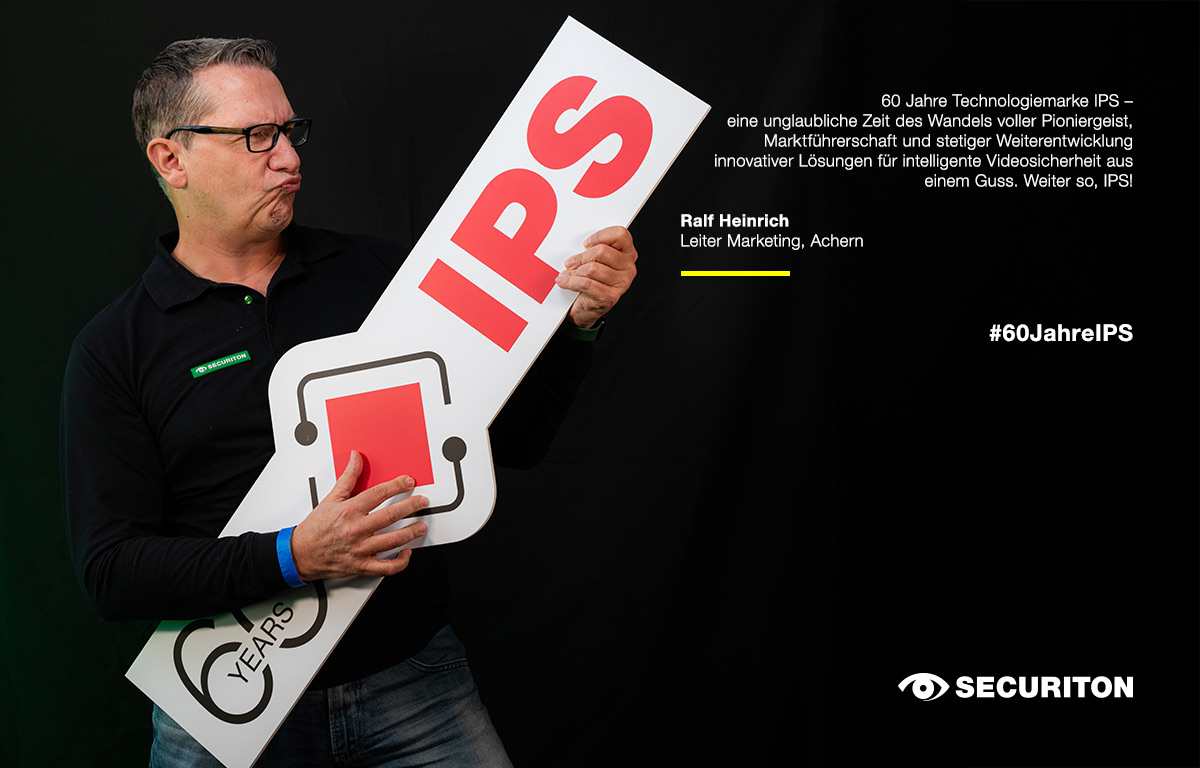 Eine Person posiert mit dem 60 Jahre IPS Logo in den Händen. Rechts daneben steht ein Glückwunsch zum Geburtstag.